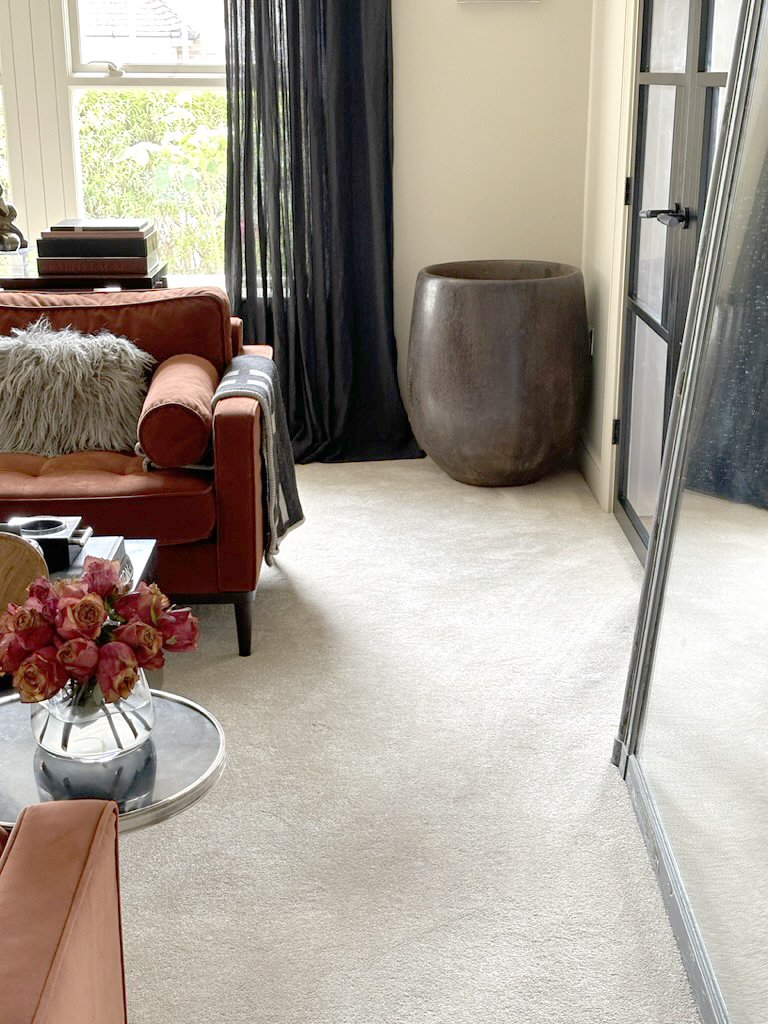 warm neutral beige living room carpet with orange sofa